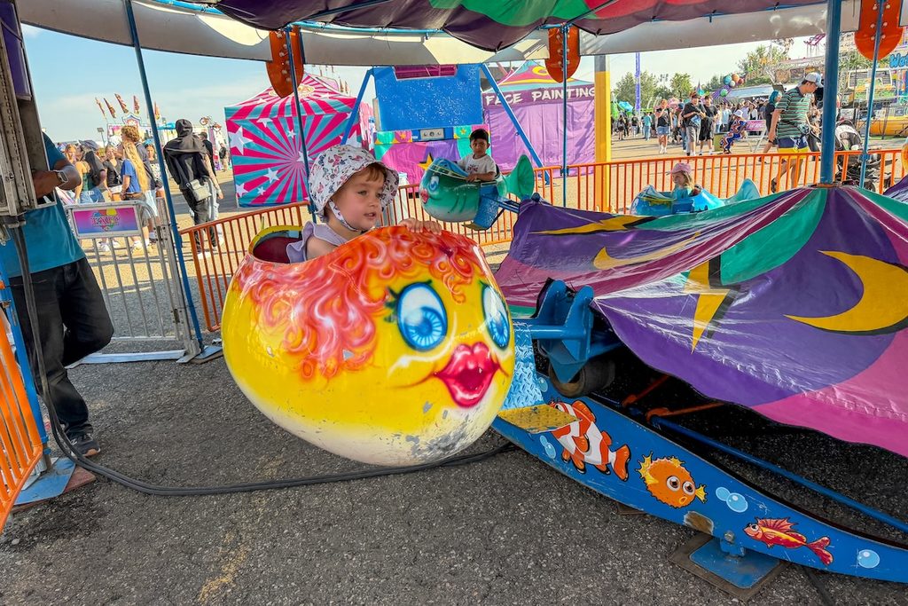 Our little girl enjoying one of her first carnival rides during Whoop-Up Days.