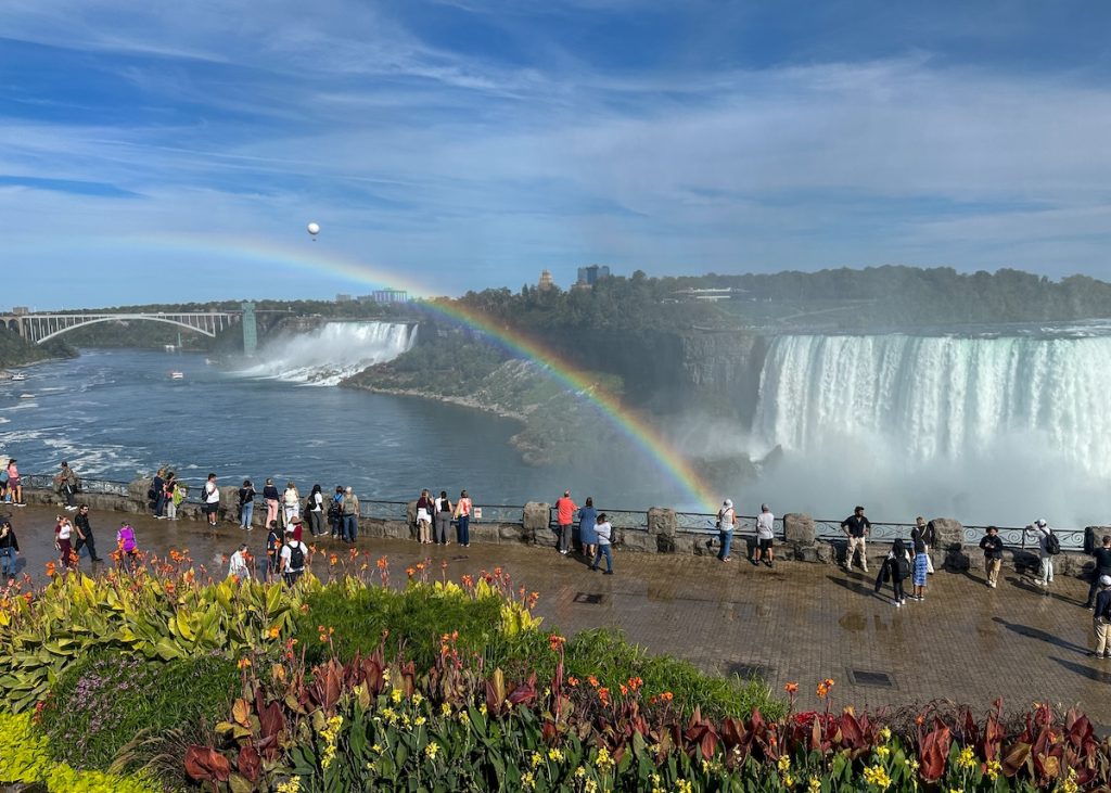 Niagara Falls boardwalk views of the falls with a rainbow.